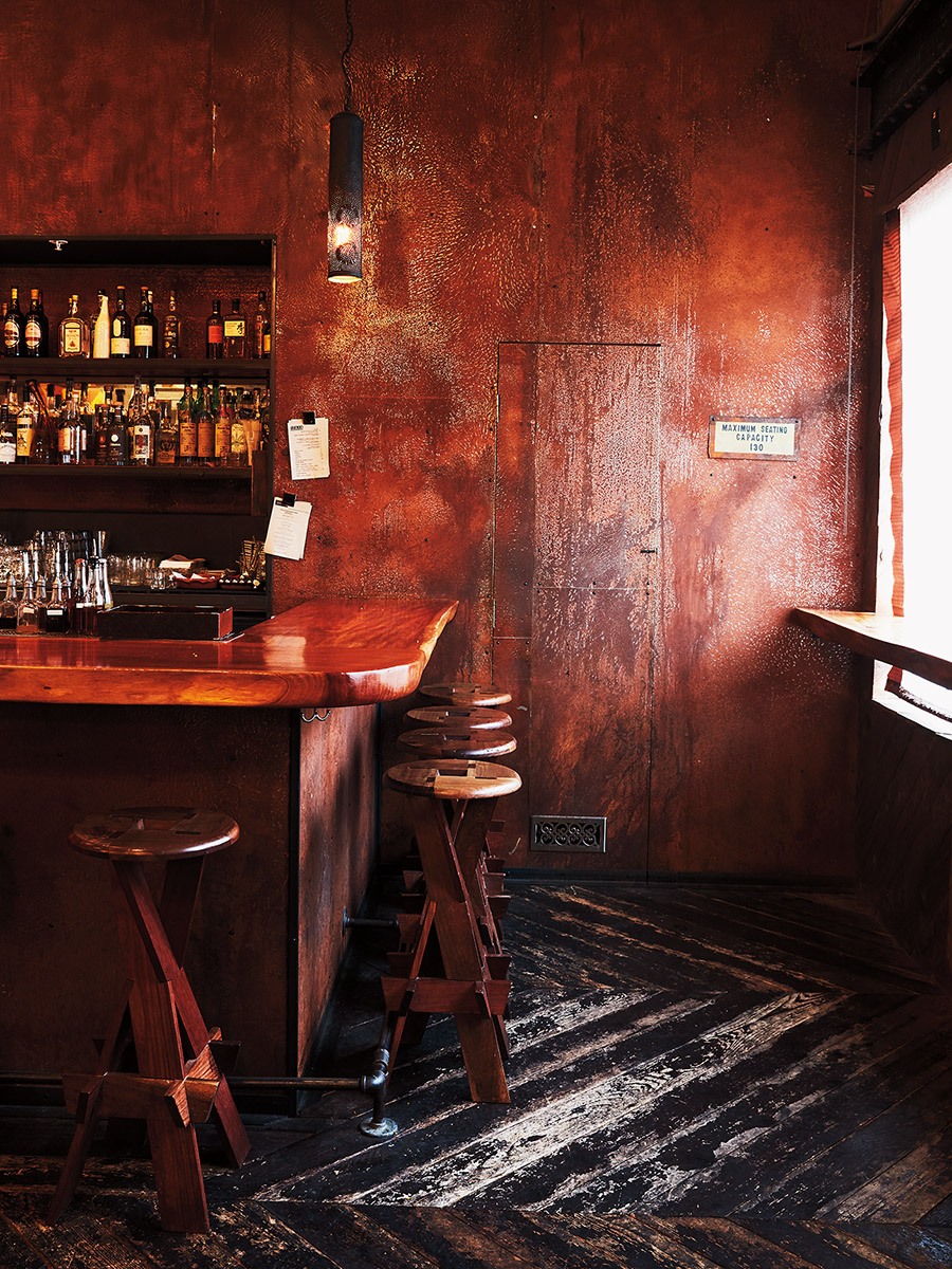 dark interior in a restaurant with stools and a wooden bar