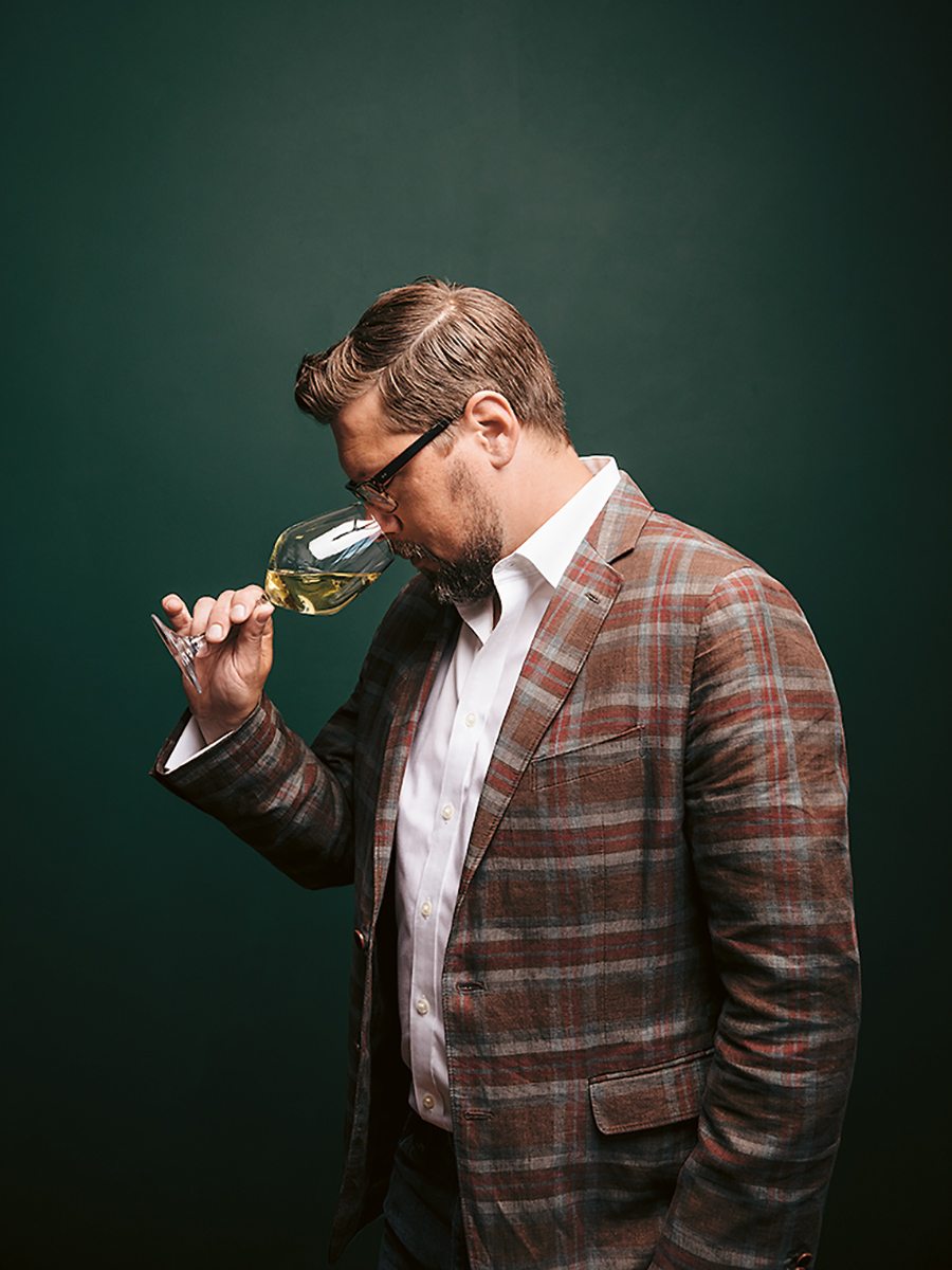 wine maker sniffing deeply into a glass of white wine