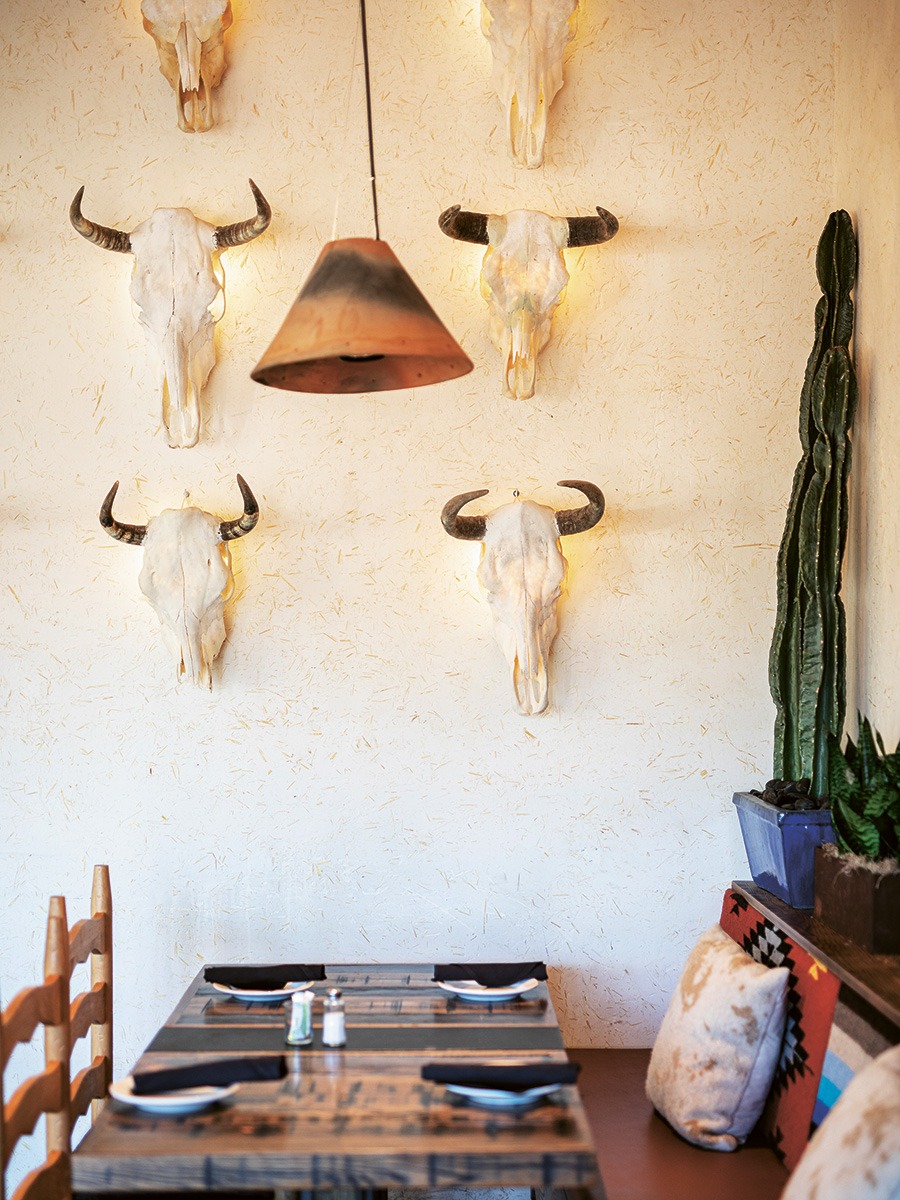 cattle skulls on wall with lamp and table