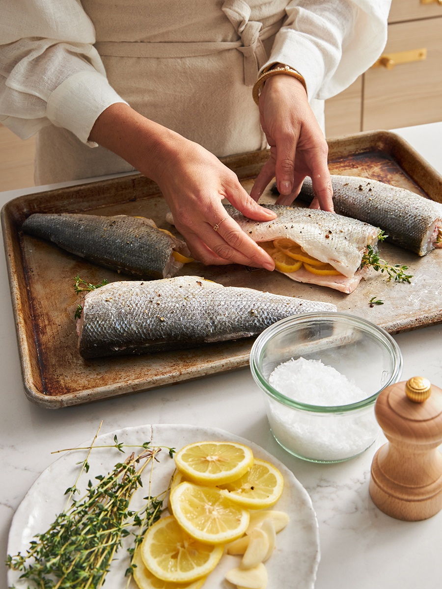 Kim Kushner stuffing salmon with thyme and lemons on baking sheet
