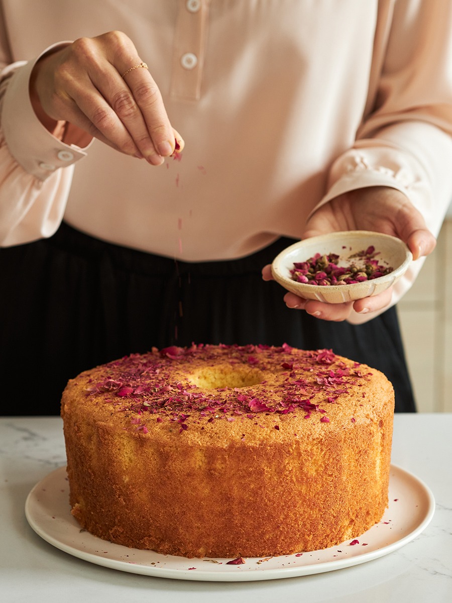 Kim Kushner sprinkling rose petals on top of unglazed cake