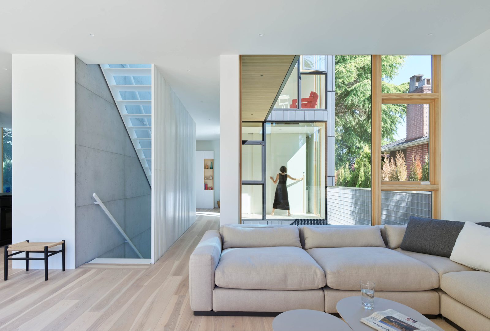 living room with views of stairs, hallway, and another room through a window