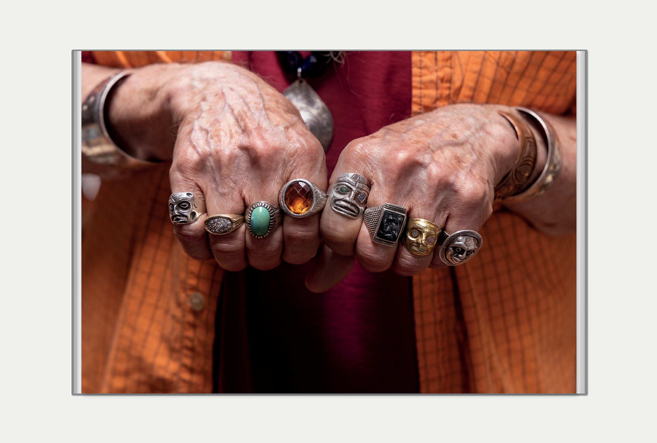 Interior image spread featuring a close up image of John David Lawrence's ornate rings on every finger