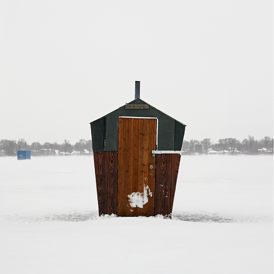 Single pentagonal shaped fishing hut with a dark wood door